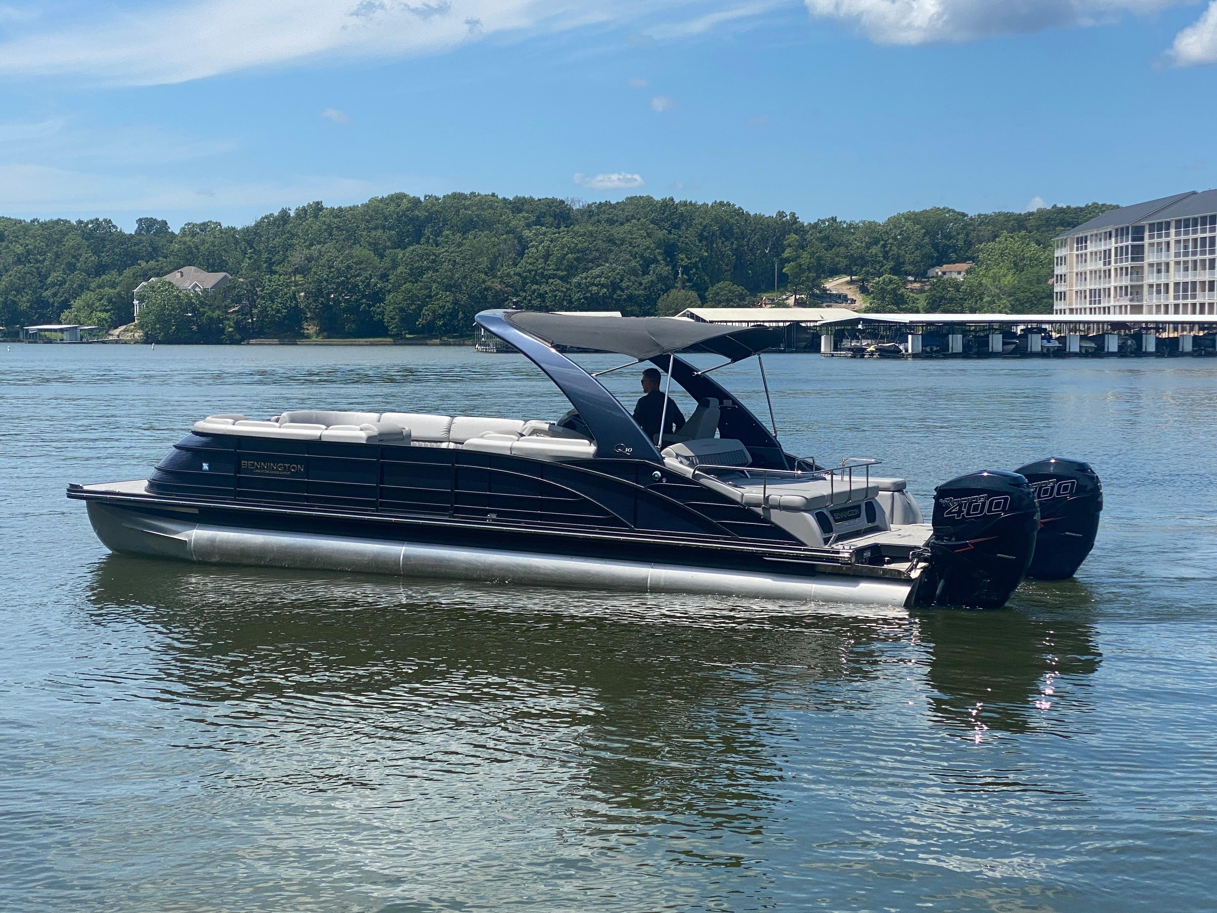 Slide: The Image of 2020 Bennington 30 QSBAX2 pontoon boat on a serene lake. - 6