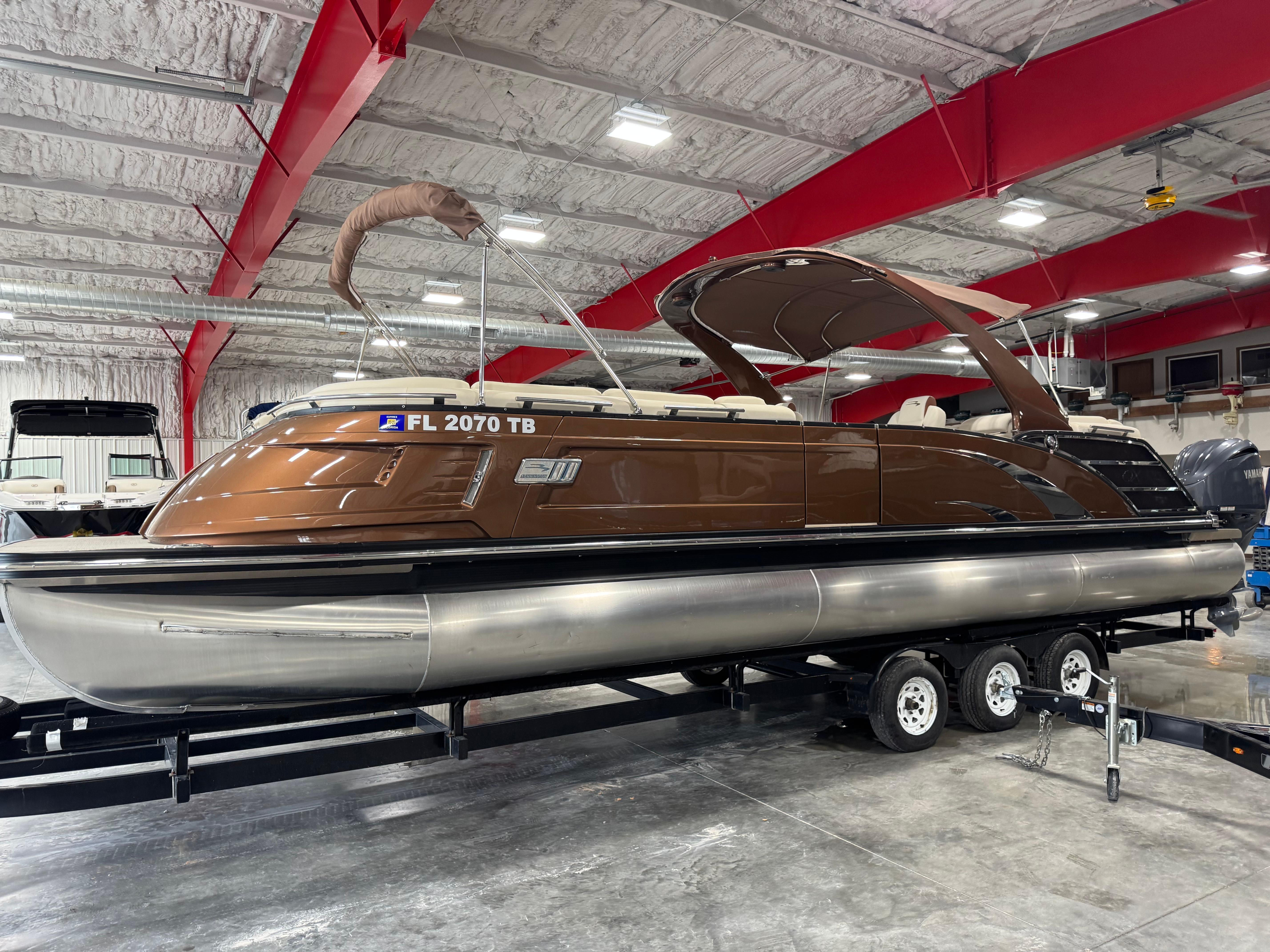 Slide: The Image of 2022 Bennington QX 30 pontoon boat on trailer in indoor storage facility. - 1
