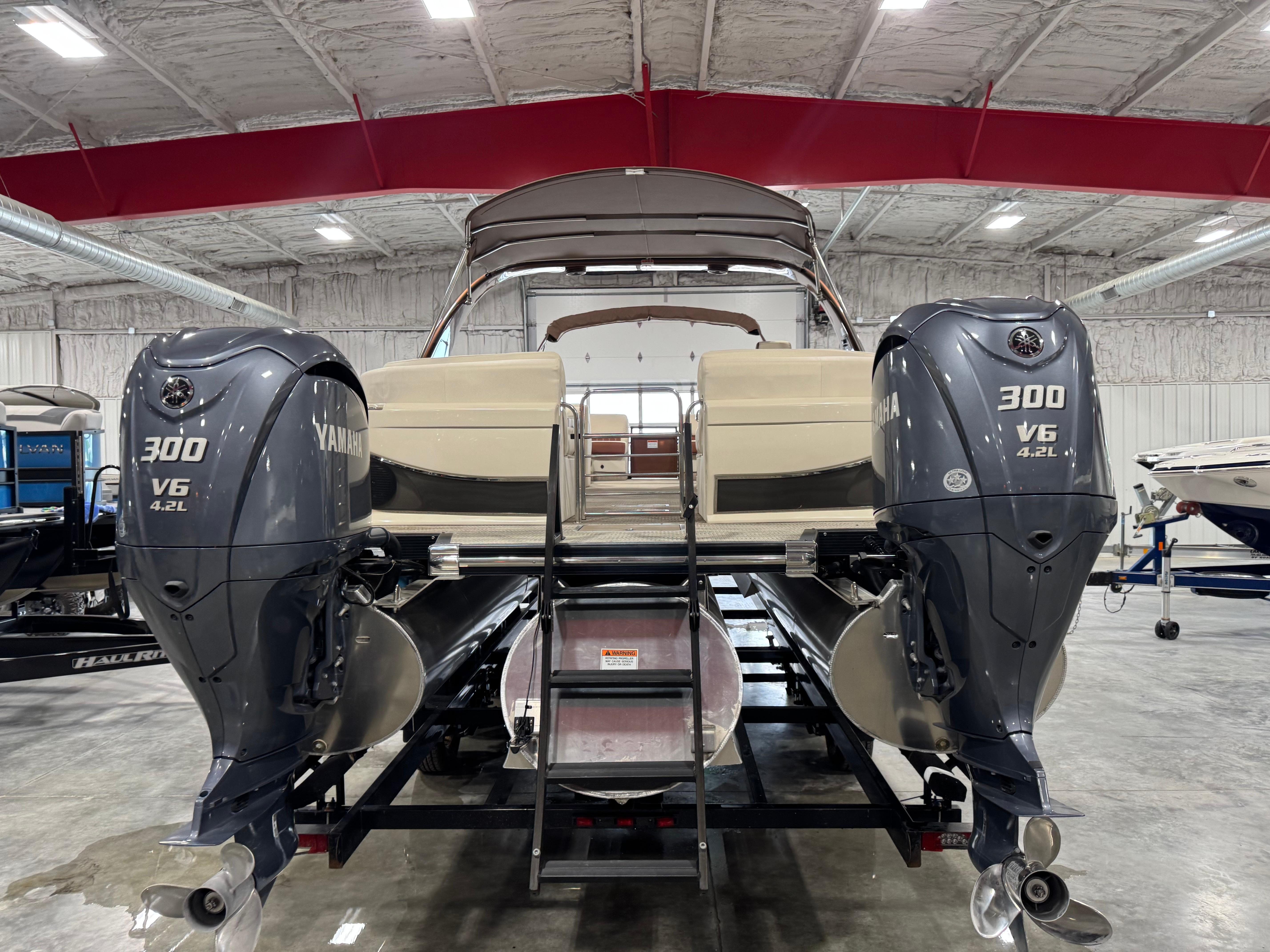 Slide: The Image of 2022 Bennington QX 30 pontoon boat with dual Yamaha 300 V6 engines in a showroom. - 5