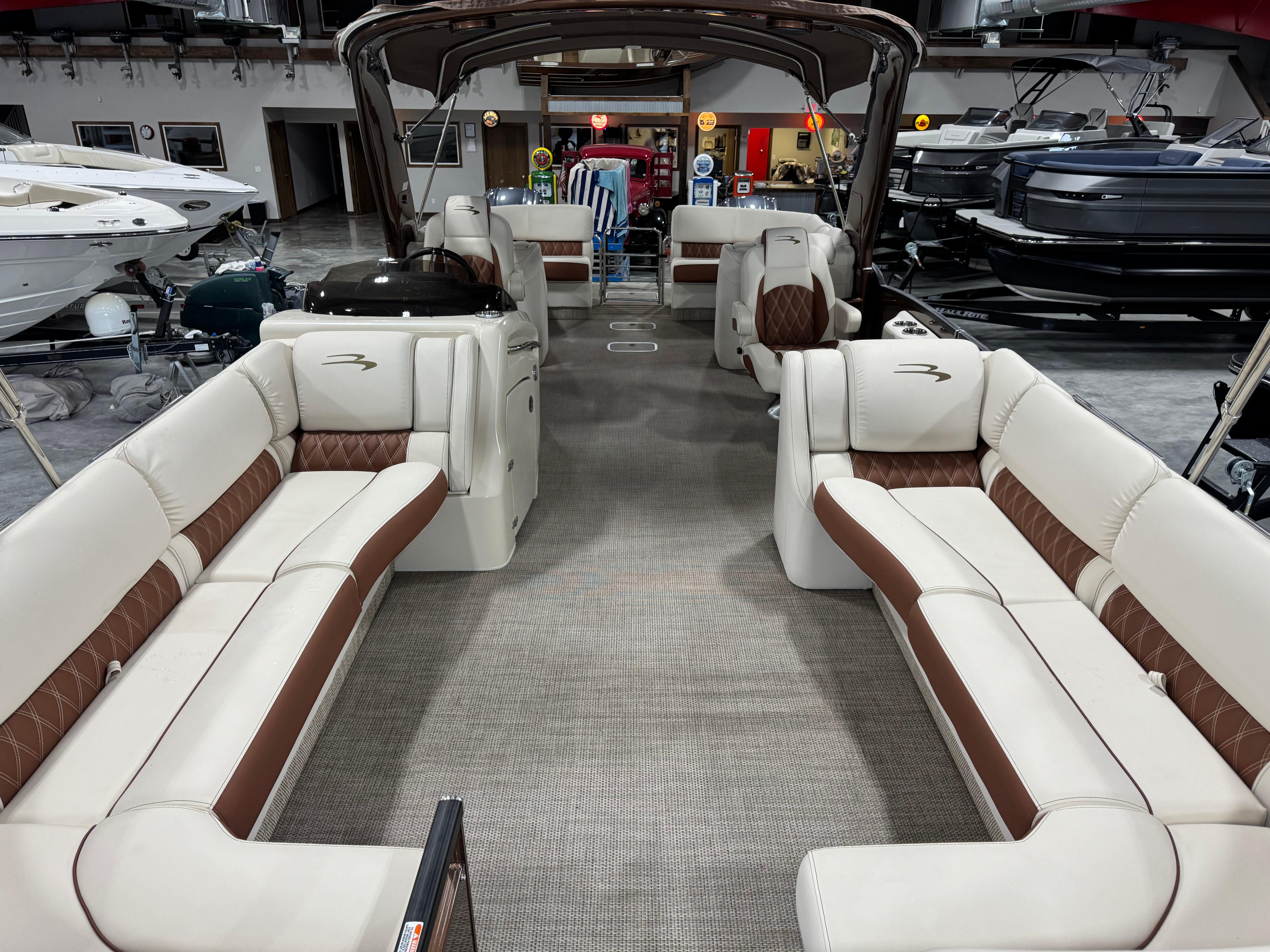 Slide: The Image of 2022 Bennington QX 30 pontoon boat interior with luxurious seating in showroom. - 6