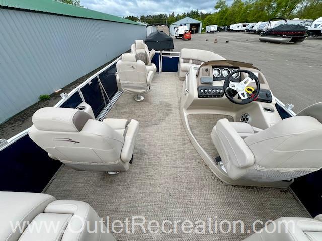 Slide: The Image of 2017 Bennington R23 pontoon boat with spacious seating and modern dashboard, parked outdoors. - 18