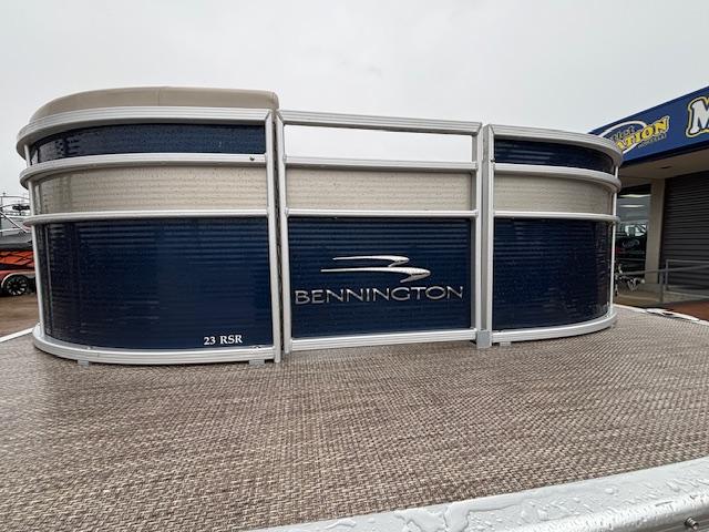 Slide: The Image of 2017 Bennington R23 pontoon boat with blue and beige exterior, displayed at a dealership. - 3