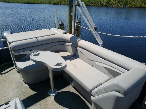 Slide: The Image of 2020 Bennington SV 20 SLV pontoon boat with comfortable seating and table by the water. - 15