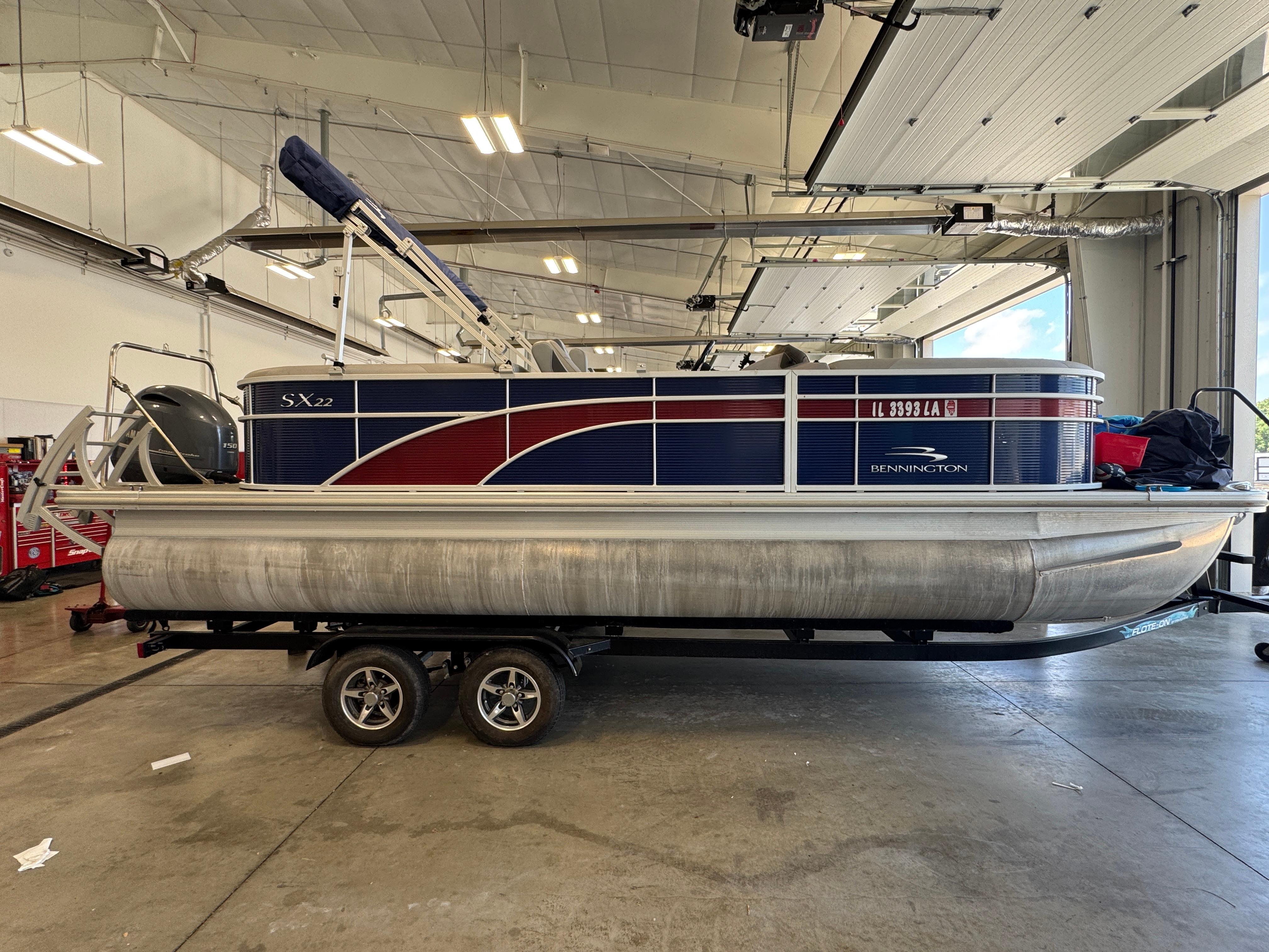 Slide: The Image of 2020 Bennington SX 22 SSRX pontoon boat on trailer in indoor storage facility. - 1