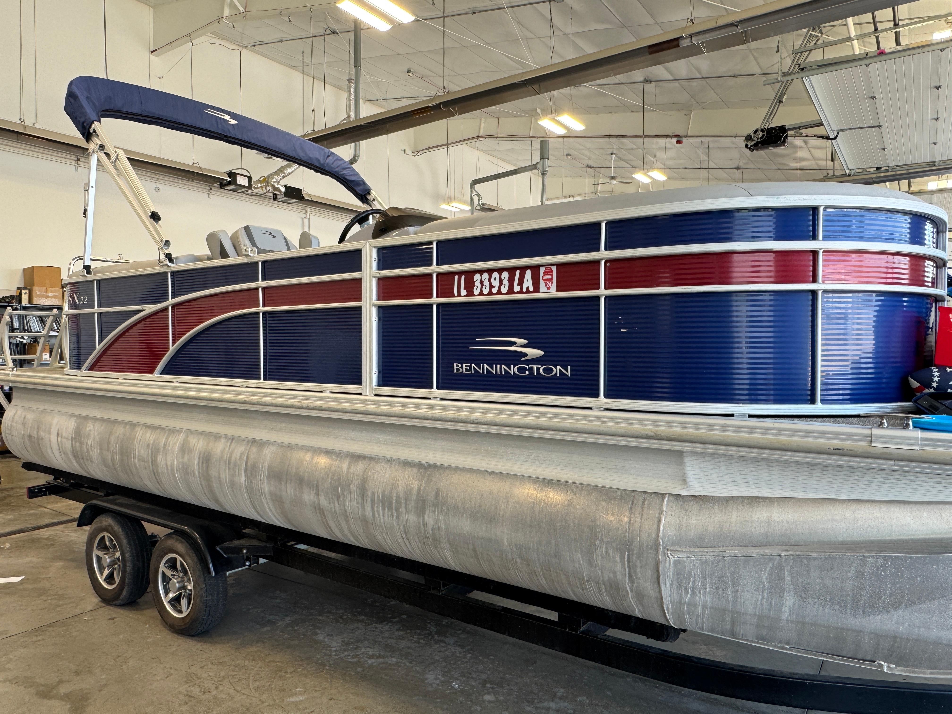 Slide: The Image of 2020 Bennington SX 22 SSRX pontoon boat on trailer in indoor storage. - 2