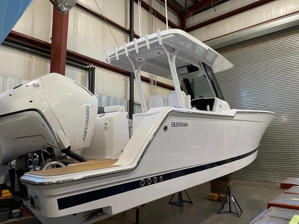 Slide: The Image of 2023 Bertram 28 CC boat in a warehouse, side view. - 11