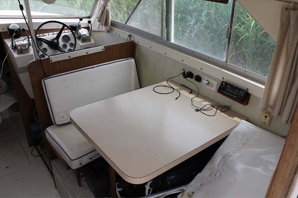 Slide: The Image of 1972 Bertram 28 Flybridge interior with dining table and helm station. - 14