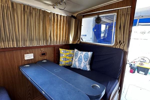 Slide: The Image of Interior of 1980 Bertram 33 Sport Fisherman with seating and nautical-themed pillows. - 15