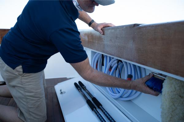 Slide: The Image of Man organizing storage compartment on 2023 Bertram 35 Flybridge boat. - 14