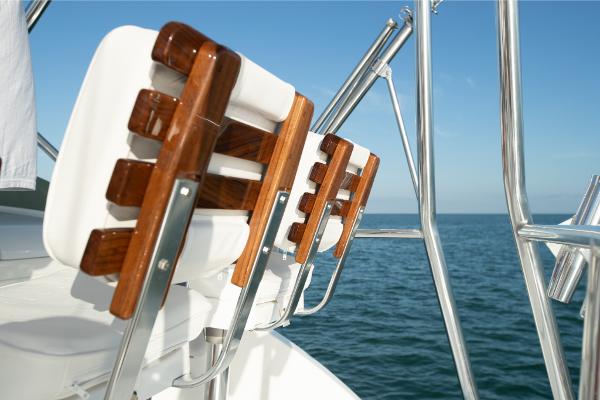Slide: The Image of Bertram 35 Flybridge 2023 boat seats with wooden accents overlooking the ocean. - 26
