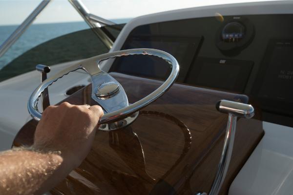 Slide: The Image of Hand steering 2023 Bertram 35 Flybridge yacht on open water. - 27