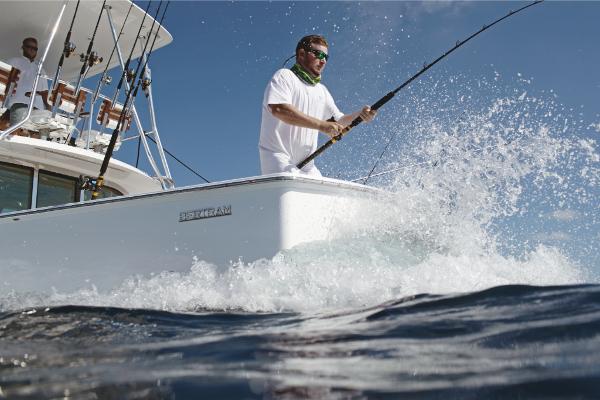 Slide: The Image of Man fishing on a 2023 Bertram 35 Flybridge boat in the ocean. - 34