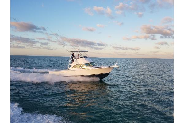 Slide: The Image of 2023 Bertram 35 Flybridge cruising on open water at sunset. - 39