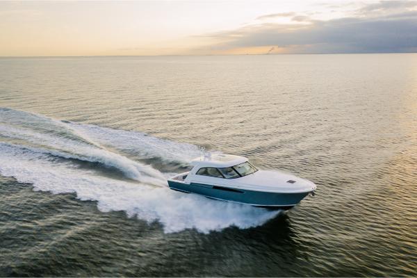 Slide: The Image of 2023 Bertram 50 Sport yacht cruising at sunset on open water. - 14