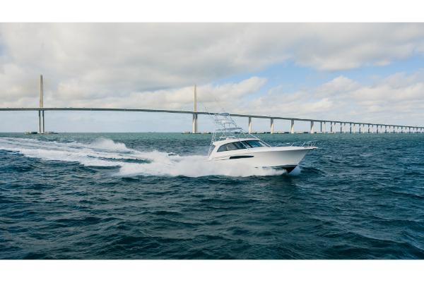 Slide: The Image of 2023 Bertram 50 Sport yacht cruising under a bridge on open water. - 15