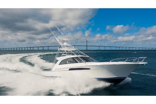 Slide: The Image of 2023 Bertram 50 Sport yacht cruising on open water with a bridge in the background. - 17