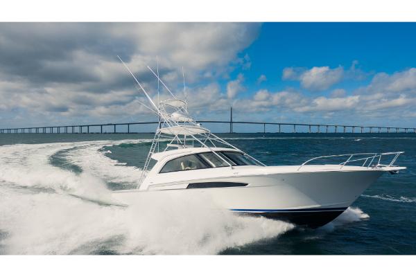 Slide: The Image of 2023 Bertram 50 Sport yacht cruising on open water with bridge in background. - 18