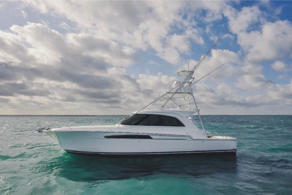 Slide: The Image of 2023 Bertram 50 Sport yacht on open water under cloudy sky. - 2