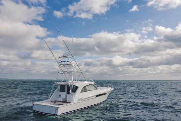 Slide: The Image of 2023 Bertram 50 Sport yacht on open sea under cloudy sky. - 3