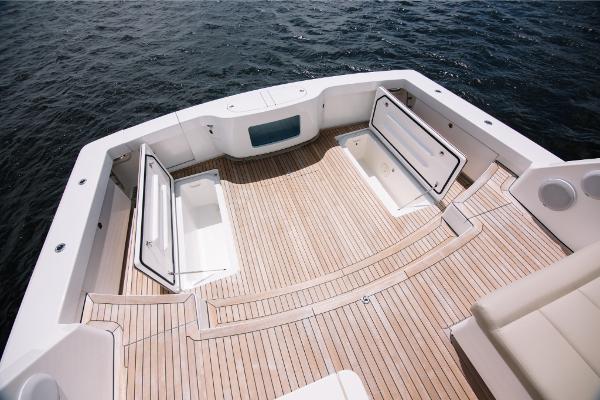 Slide: The Image of 2023 Bertram 50 Sport boat deck with storage compartments and teak flooring. - 33