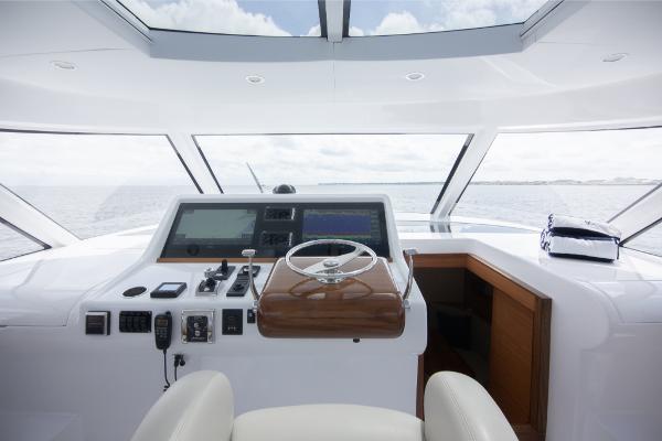 Slide: The Image of 2023 Bertram 50 Sport yacht helm with modern navigation equipment and panoramic ocean view. - 40