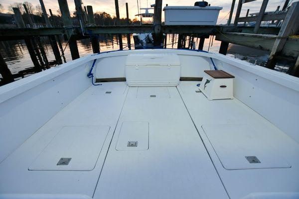 Slide: The Image of 1965 Bertram Sportfisher boat deck at sunset, docked in a marina. - 13