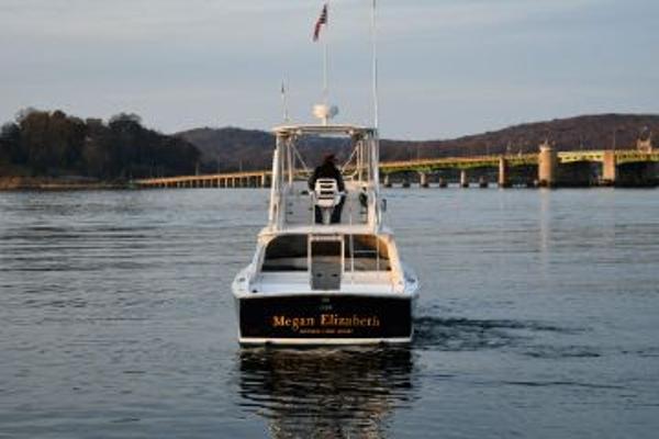 Slide: The Image of 1965 Bertram Sportfisher boat on calm water near a bridge. - 3