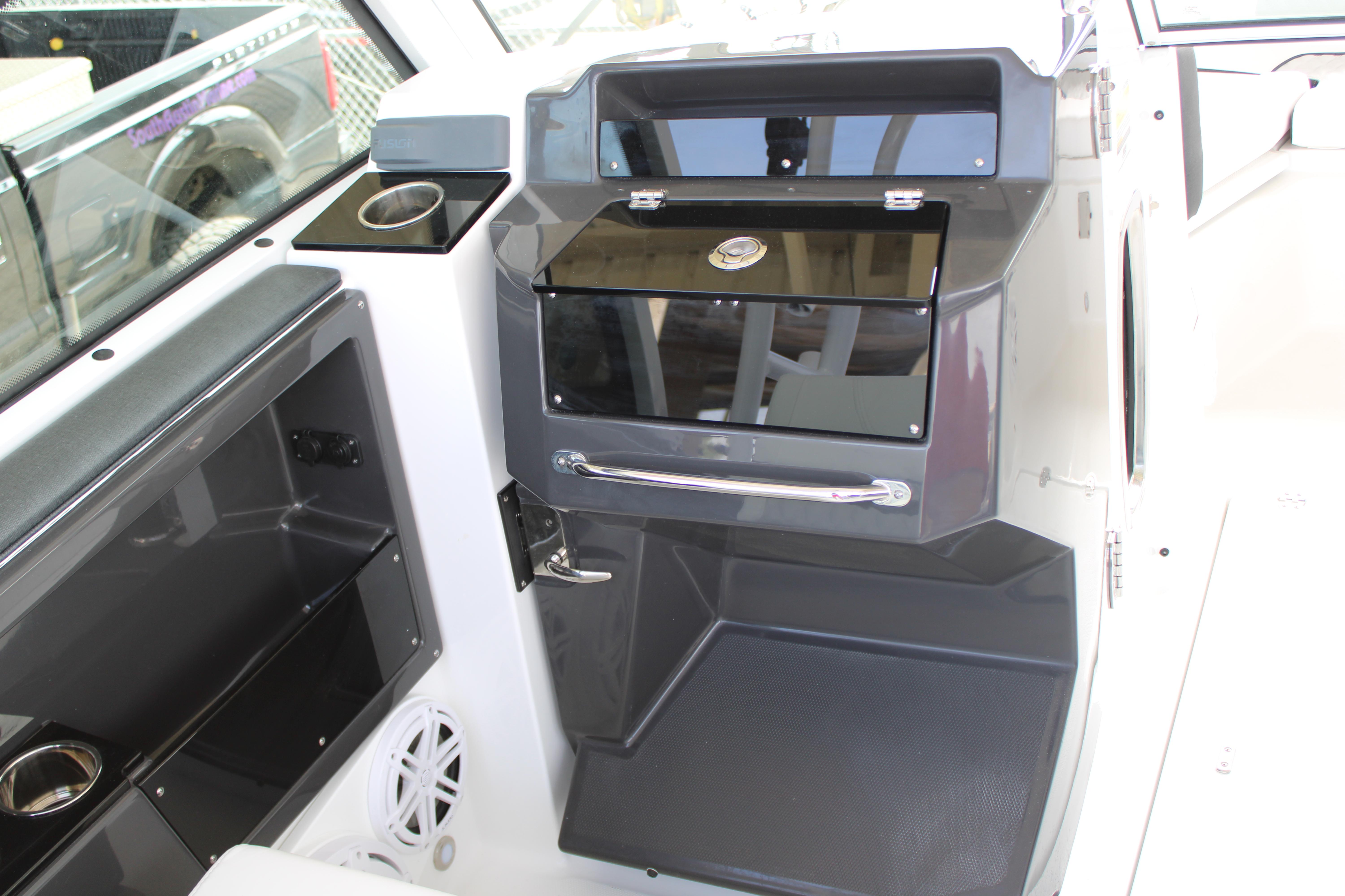 Slide: The Image of Interior of 2023 Blackfin 252 DC boat featuring storage compartments and cup holder. - 19