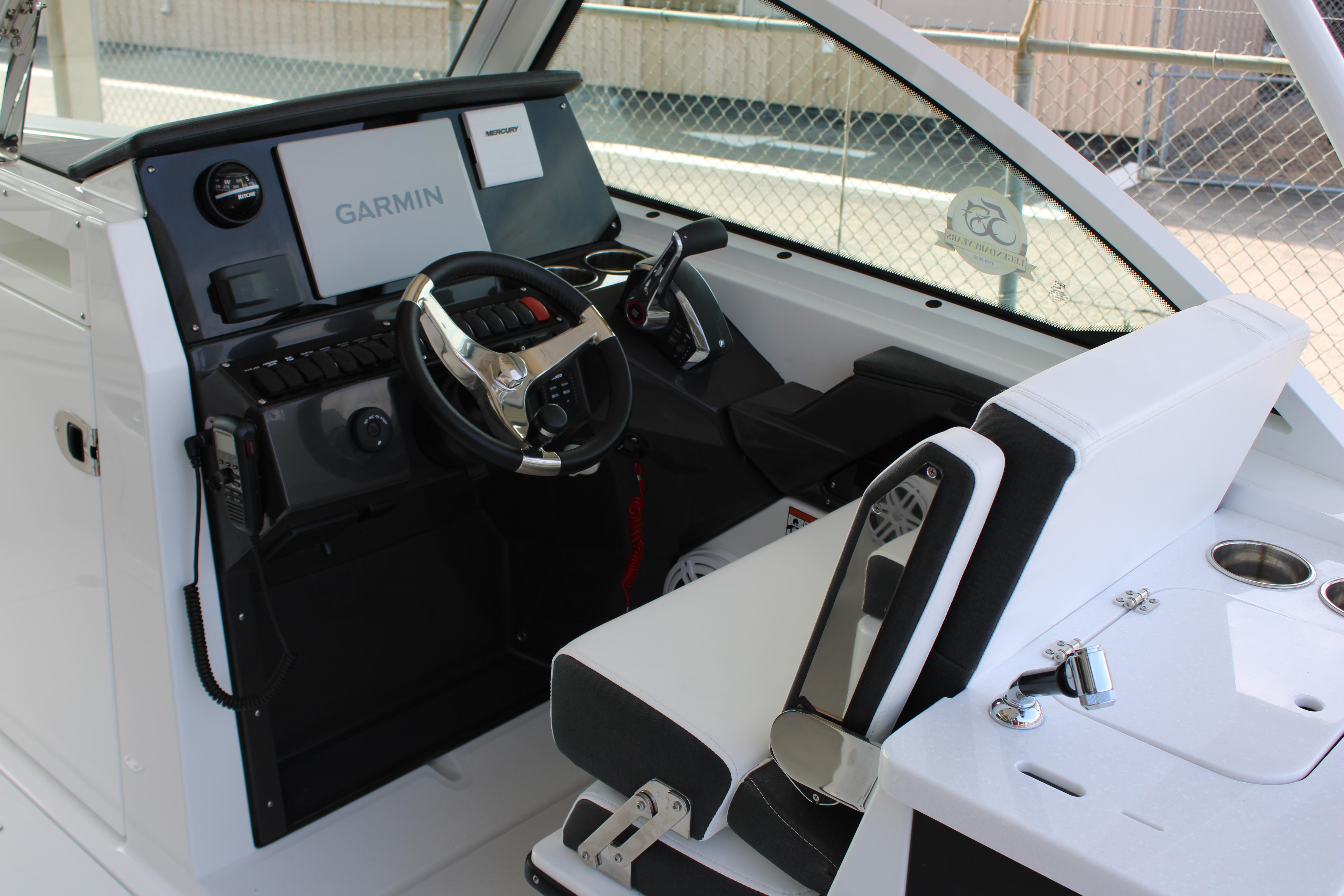 Slide: The Image of 2023 Blackfin 252 DC boat cockpit with Garmin navigation system and Mercury controls. - 24