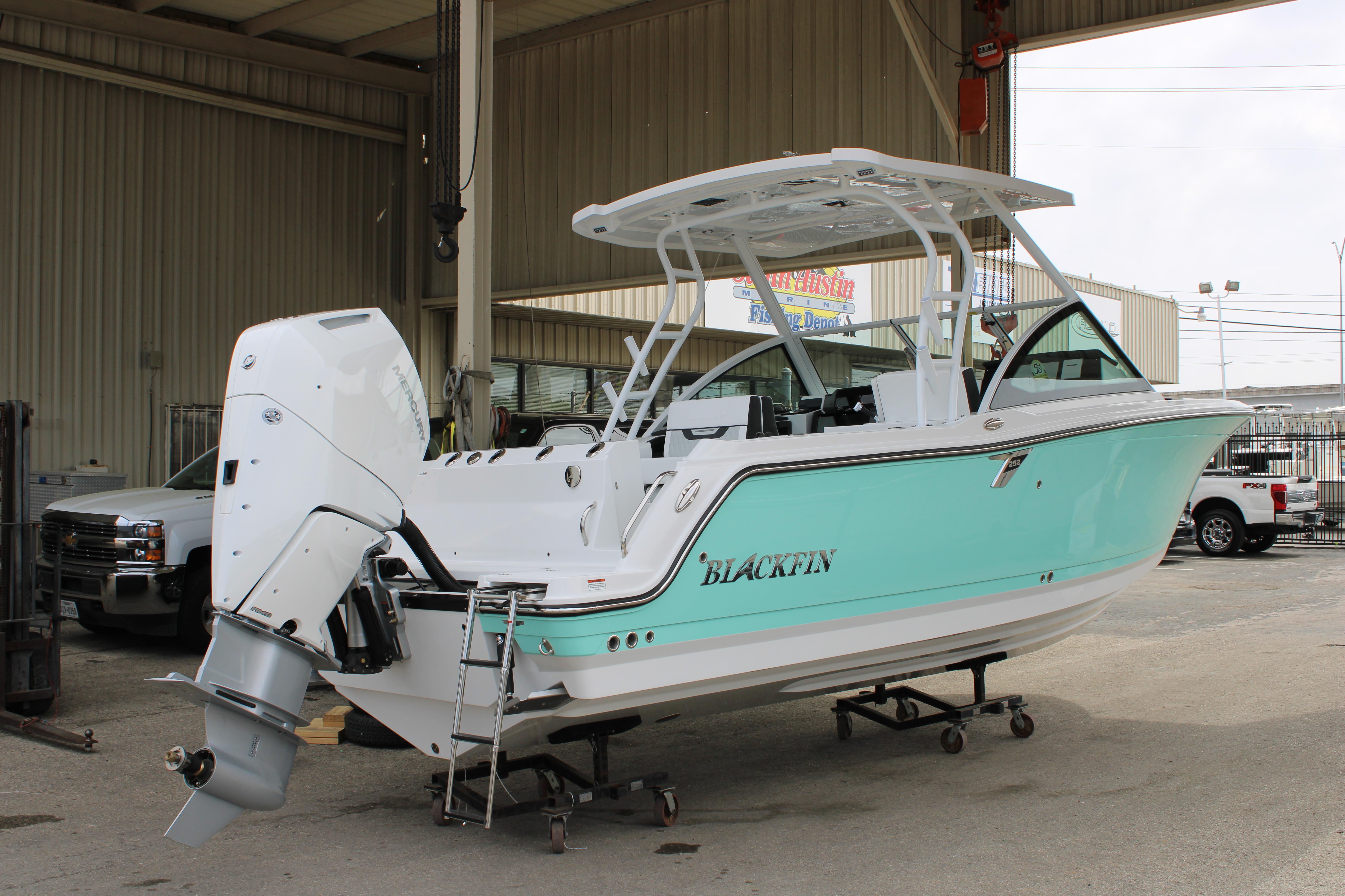 Slide: The Image of 2023 Blackfin 252 DC boat in a marina, featuring a sleek design and powerful outboard motor. - 3