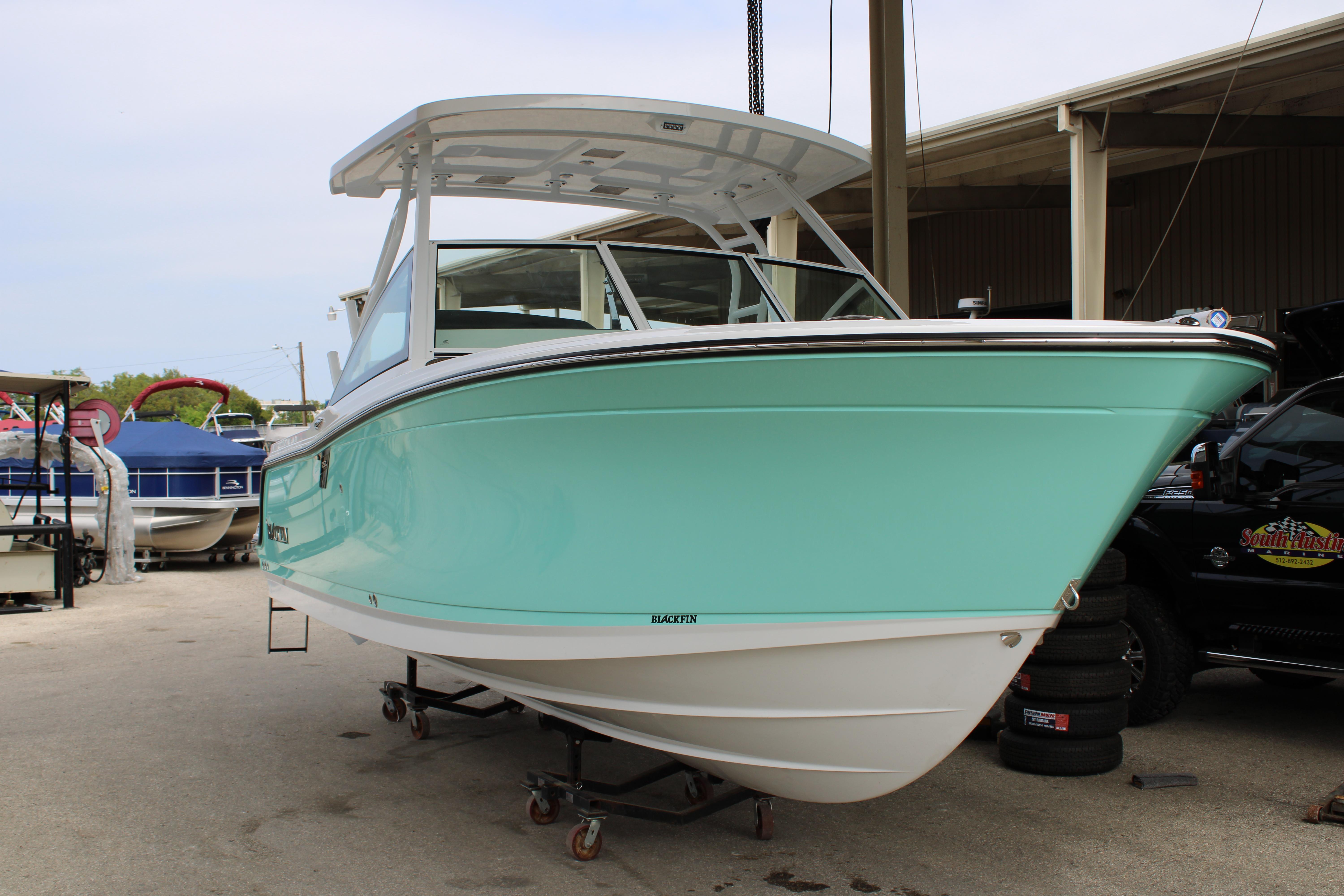 Slide: The Image of 2023 Blackfin 252 DC boat in mint green on display at a marina. - 48