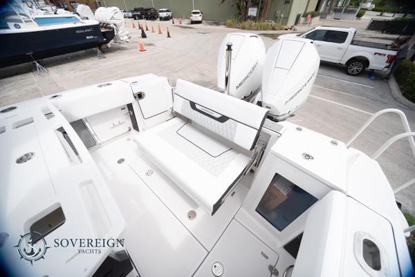 Slide: The Image of 2024 Blackfin 272 CC boat with dual engines and spacious deck at a marina. - 31