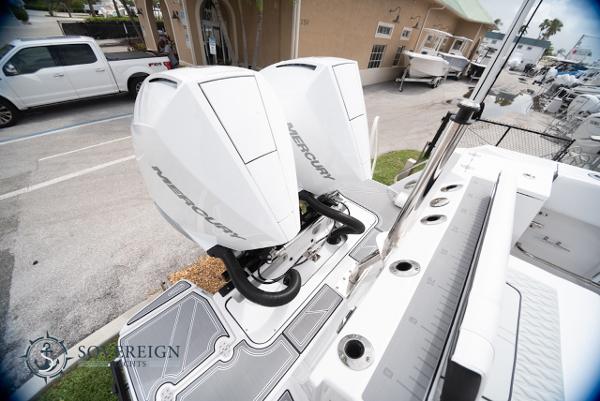 Slide: The Image of 2024 Blackfin 272 CC boat with dual Mercury outboard engines, docked at a marina. - 34