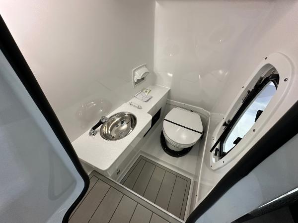 Slide: The Image of 2024 Blackfin 302 DC boat bathroom with sink, toilet, and window. - 20