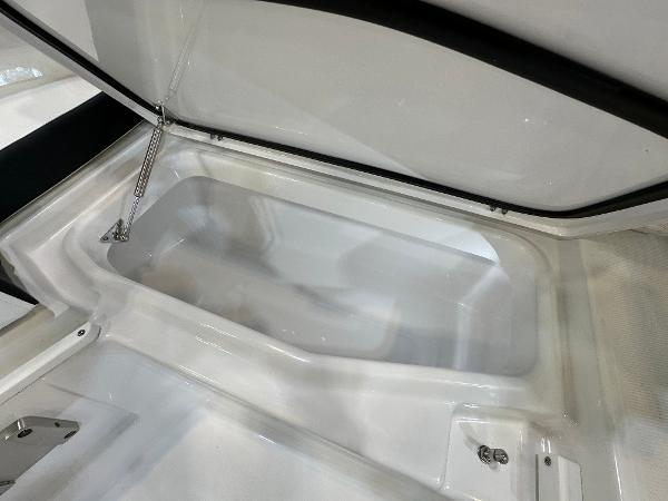 Slide: The Image of 2024 Blackfin 302 DC boat storage compartment, open lid, white interior. - 27
