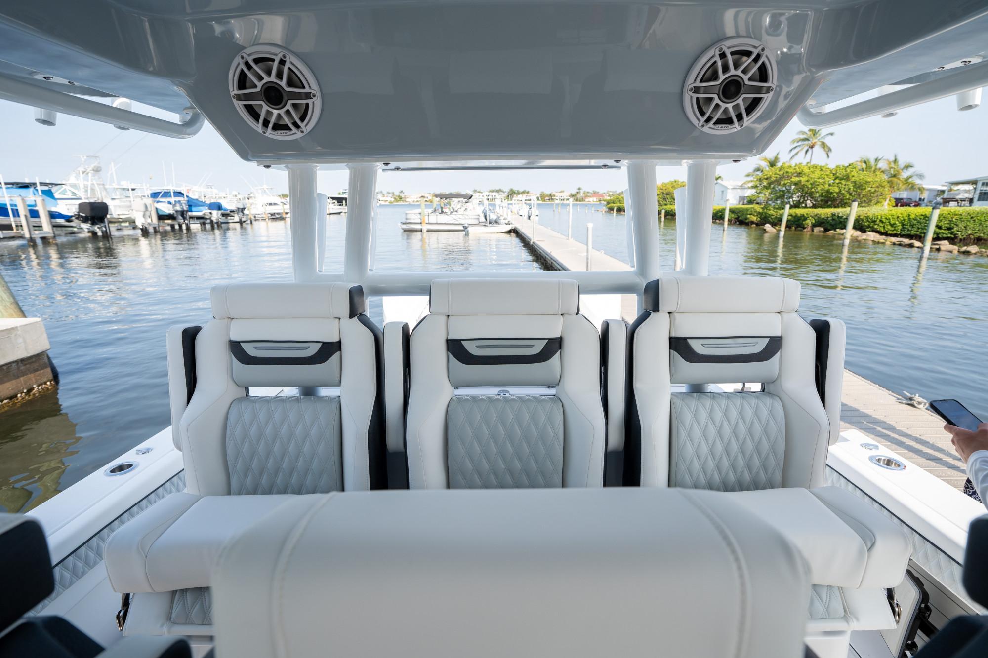 Slide: The Image of 2024 Blackfin 400 CC boat interior with luxurious seating at a marina. - 23