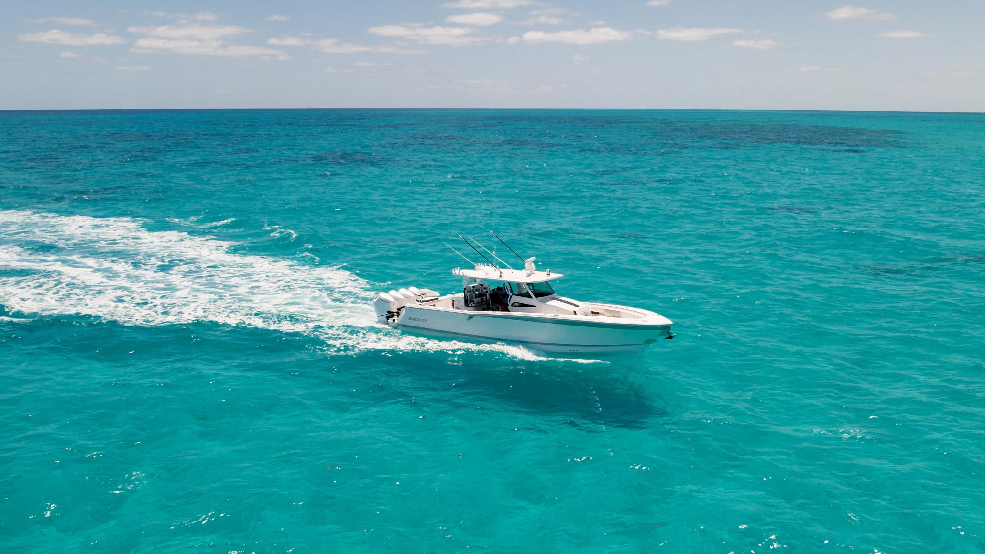 Slide: The Image of 2024 Blackfin 400 CC cruising on clear turquoise ocean waters. - 7