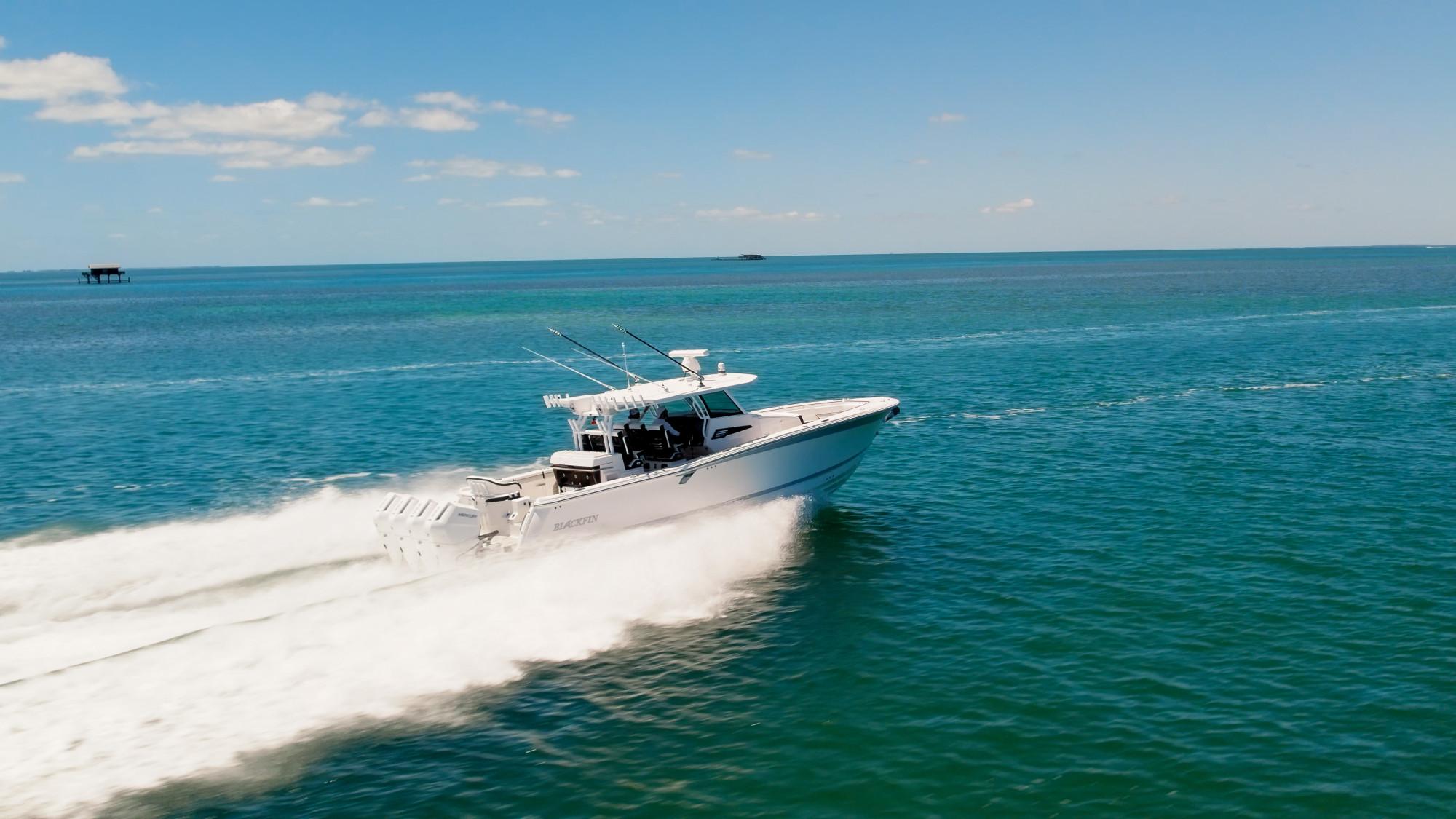 Slide: The Image of 2024 Blackfin 400 CC boat cruising on open blue water under clear skies. - 8