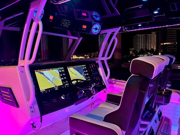 Slide: The Image of Luxurious 2025 Blackfin 400 CC boat cockpit with illuminated controls and seating at night. - 17