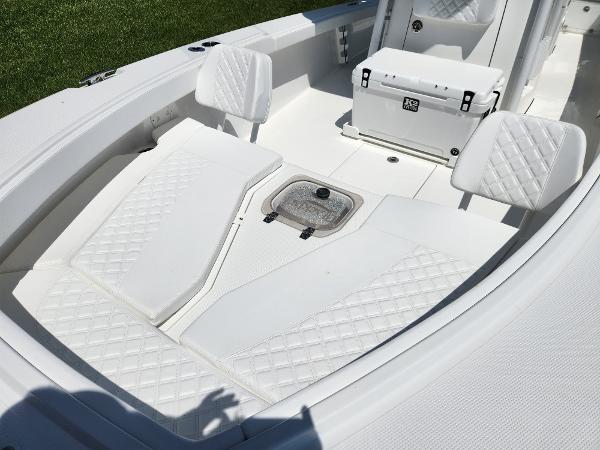 Slide: The Image of 2025 BlackJack 256 Coastal boat interior with white cushioned seating and storage. - 10