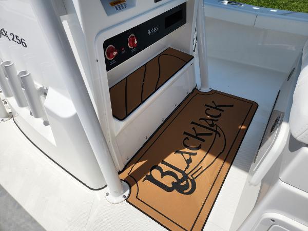 Slide: The Image of 2025 BlackJack 256 Coastal boat interior with branded mat and control panel. - 16
