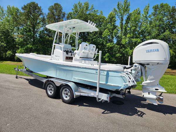 Slide: The Image of 2025 BlackJack 256 Coastal boat with Yamaha engine on trailer, parked outdoors. - 2