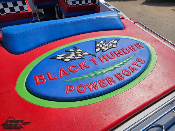 Slide: The Image of 2002 Black Thunder 460 SC powerboat logo with vibrant colors and checkered flags. - 41