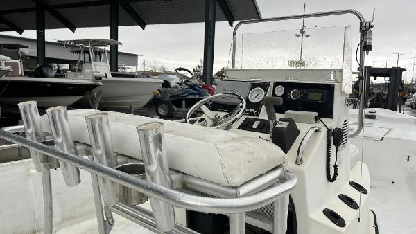 Slide: The Image of 2000 Blazer 1860 boat console with steering wheel and rod holders in a marina setting. - 9