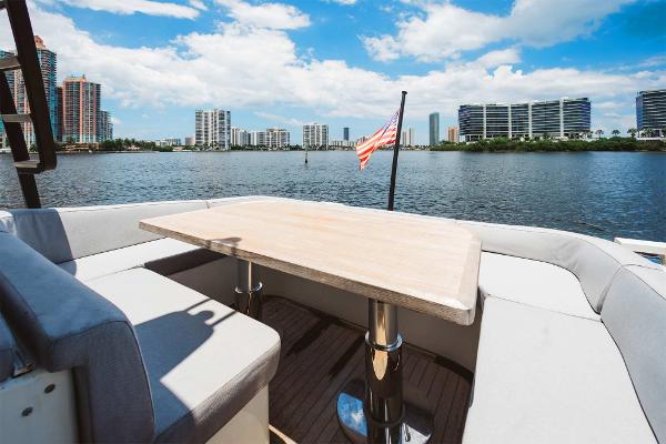 Slide: The Image of 2019 Bluegame BG62 yacht with waterfront cityscape view and American flag. - 11