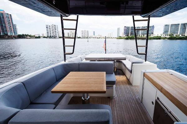Slide: The Image of 2019 Bluegame BG62 yacht with spacious outdoor seating and waterfront view. - 14