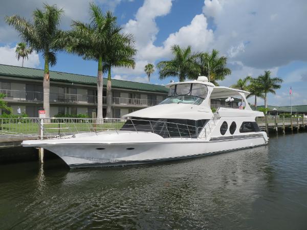 Slide: The Image of 2000 Bluewater 5800 yacht docked near palm trees and waterfront buildings. - 10