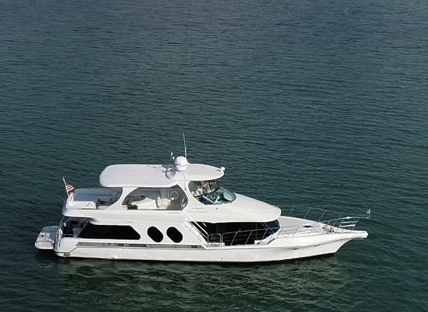 Slide: The Image of White 2000 Bluewater 5800 yacht cruising on calm waters. - 12