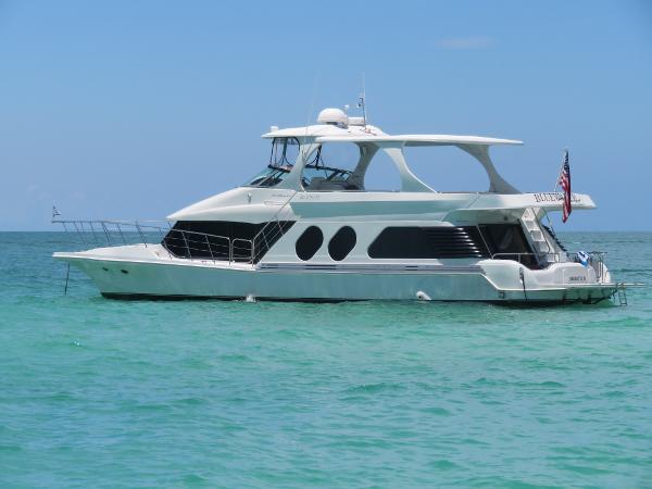 Slide: The Image of Luxury Bluewater 5800 yacht, 2000 model, anchored in clear turquoise waters. - 13