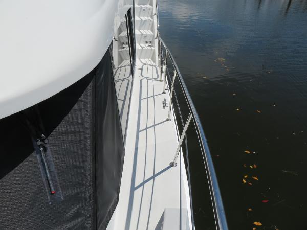 Slide: The Image of Side deck view of a 2000 Bluewater 5800 yacht on calm water. - 21